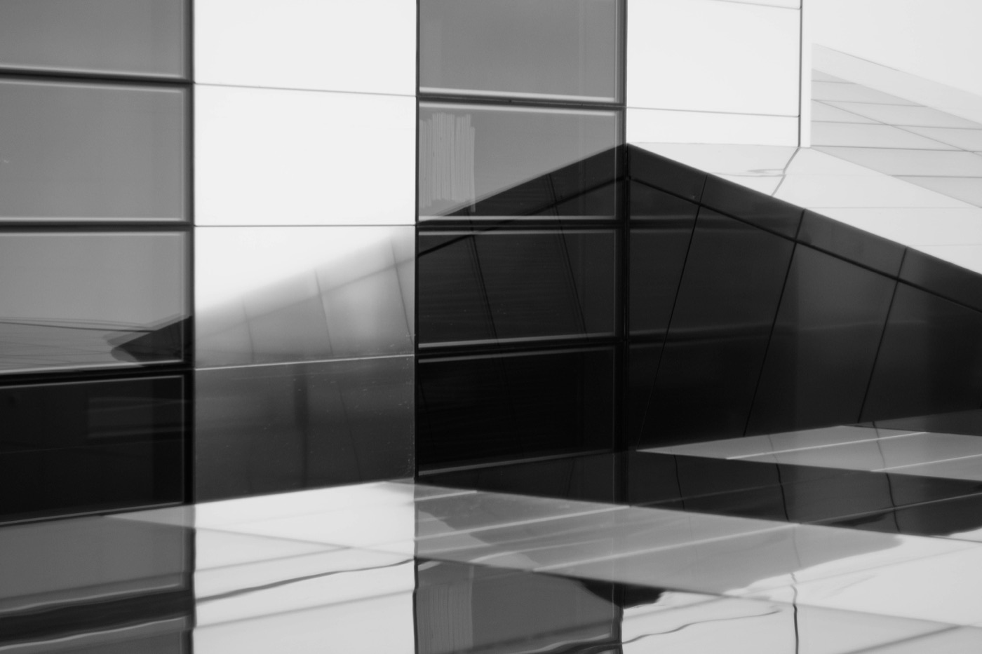 Abstrakte Spiegelungen und überlagerte Konturen in einer Glasfassade